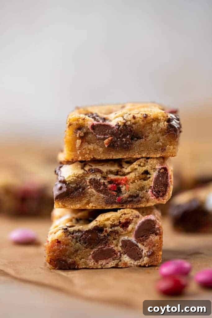 Sweet & Simple Valentine M&M Blondies 3 Stack of freshly baked Valentine's Day M&M's blondies on a cooling rack.