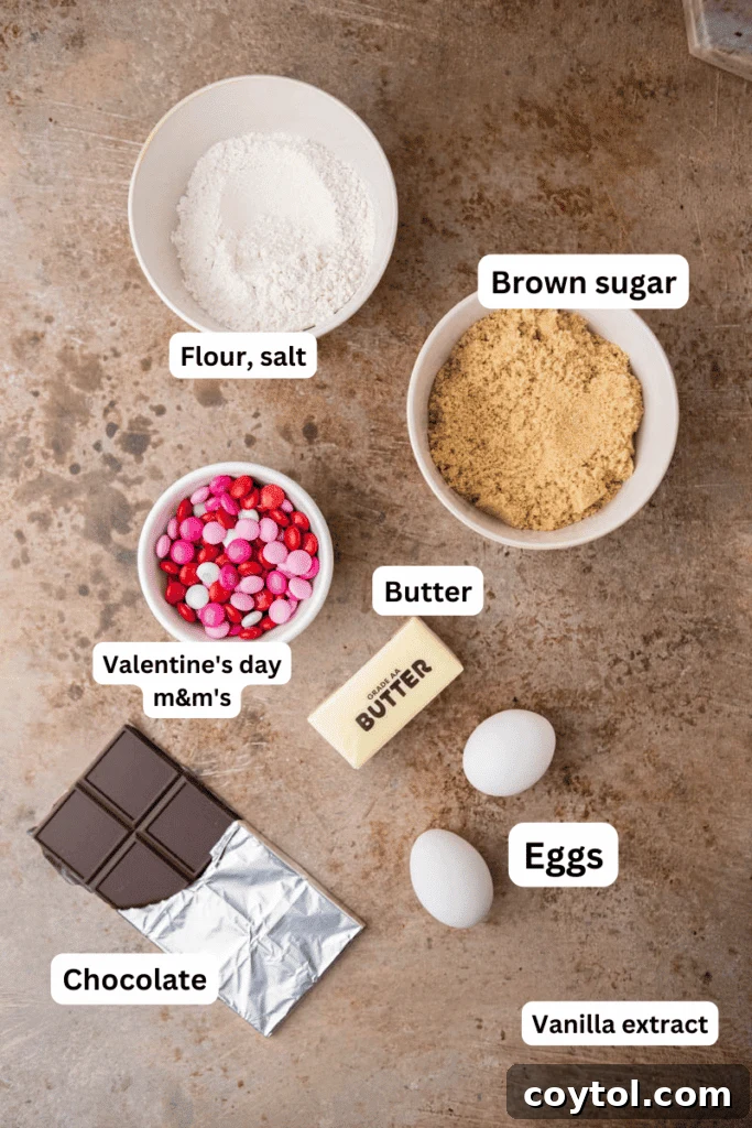 Sweet & Simple Valentine M&M Blondies 4 Assortment of baking ingredients including butter, brown sugar, eggs, flour, M&M's, and chocolate on a kitchen counter.