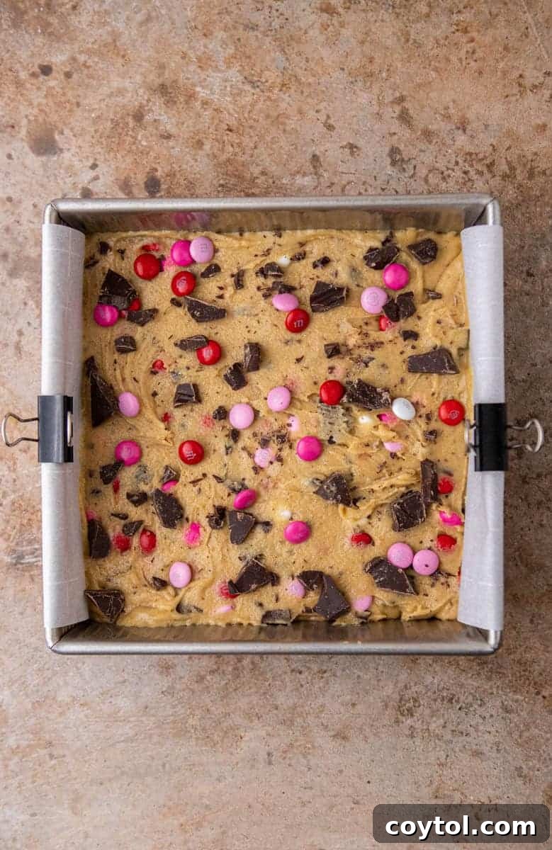 Sweet & Simple Valentine M&M Blondies 7 Unbaked blondie batter spread evenly in an 8x8 inch baking pan, topped with extra M&M's and chocolate.