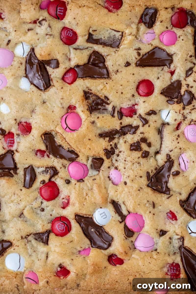Sweet & Simple Valentine M&M Blondies 8 Freshly baked Valentine's Day M&M's blondies in the pan, showing a crinkly top and melted chocolate.