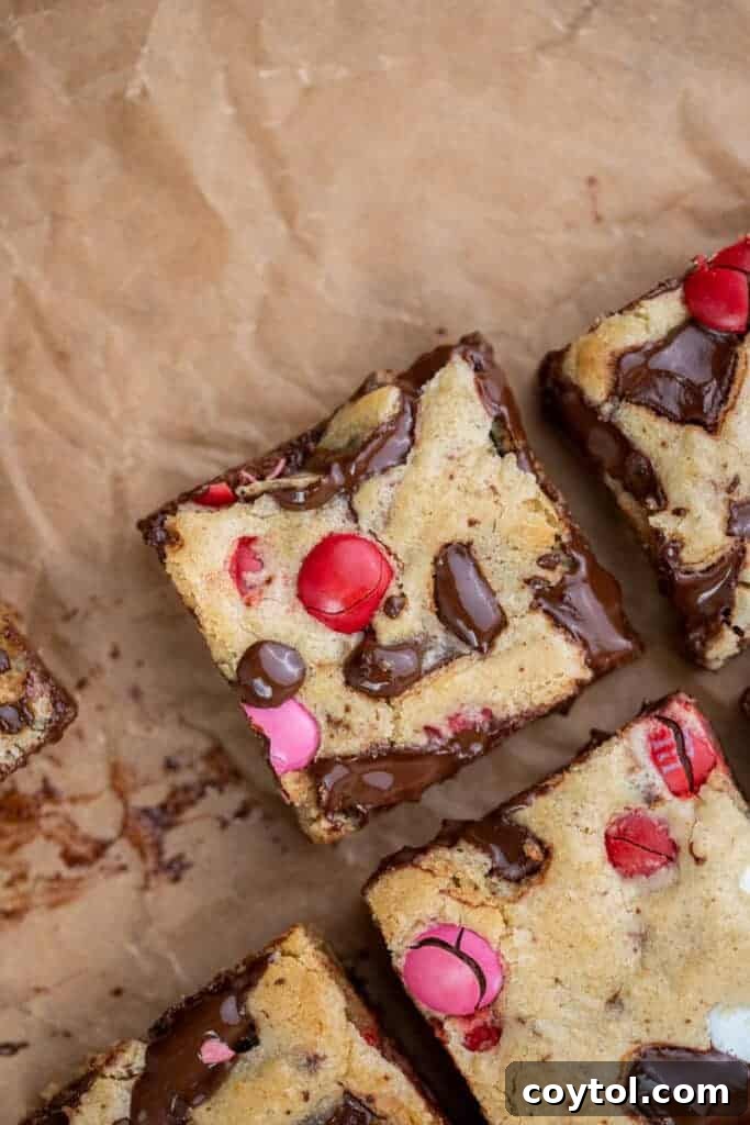 Sweet & Simple Valentine M&M Blondies 10 Several slices of Valentine's Day M&M blondies arranged on a white plate, ready to be served.