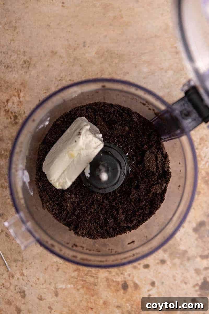 No-Fuss Valentine's Oreo Truffles 5 Wet ingredients in a food processor, showing the cream cheese ready to be mixed with crushed Oreos.
