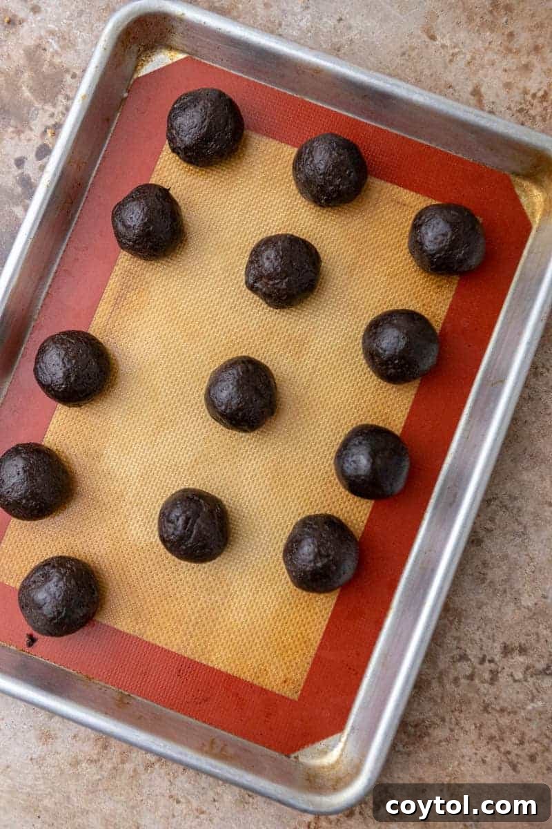 No-Fuss Valentine's Oreo Truffles 7 Uncoated Oreo truffles neatly arranged on a baking sheet, ready for chilling.