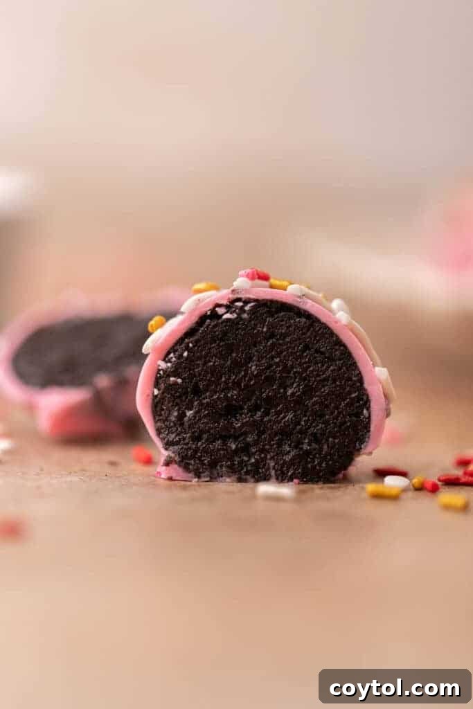 No-Fuss Valentine's Oreo Truffles 9 A Valentine's Day Oreo truffle sliced in half, revealing the dark cookie and cream cheese interior.