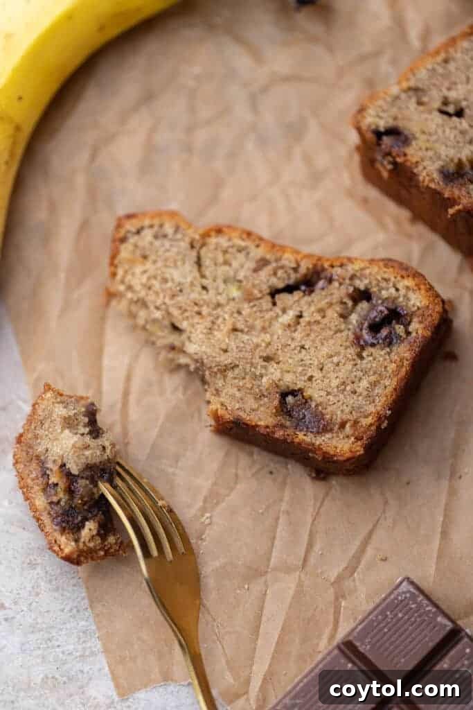 A beautiful slice of eggless banana bread studded with chocolate chunks, ready to be enjoyed.