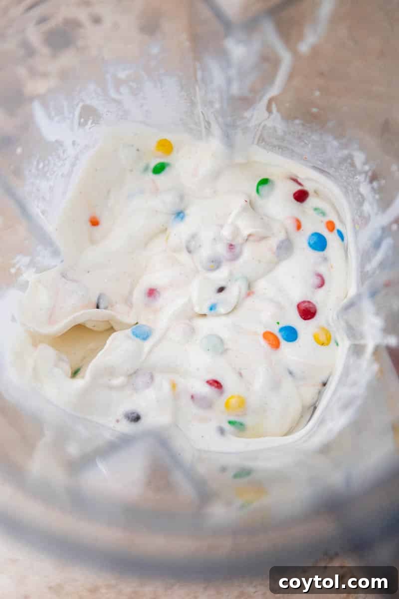Homemade M&M's McFlurry in the blender cup with M&M's mixed in, ready for serving.