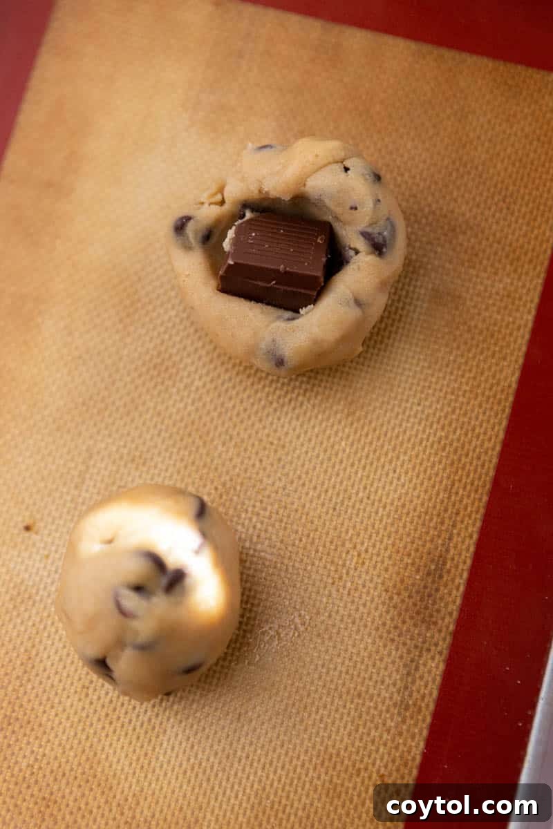 Chocolate square being stuffed into cookie dough