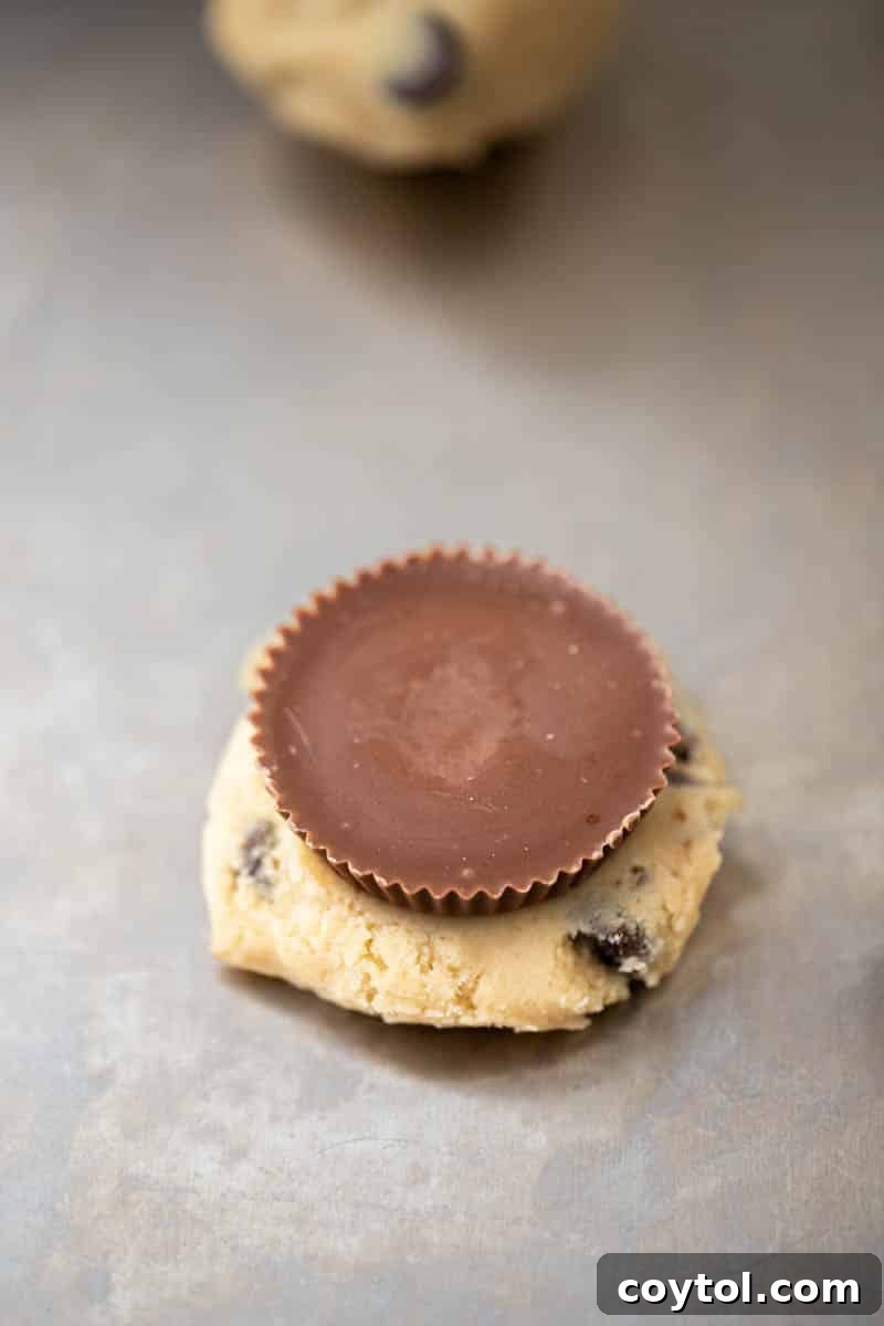 Simple Reese's Peanut Butter Explosion Chocolate Chip Cookies 7 Portioned cookie dough balls placed on a baking sheet, preparing for the oven.