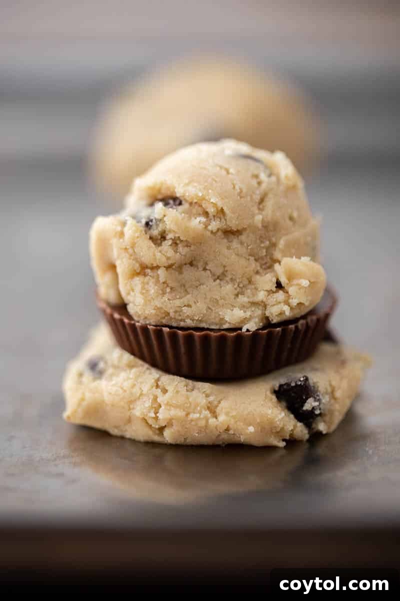 Simple Reese's Peanut Butter Explosion Chocolate Chip Cookies 8 Close-up of cookie dough balls on a baking sheet before baking.