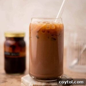 A perfectly blended iced mocha latte in a tall glass, garnished with a chocolate swirl and possibly whipped cream, ready to be enjoyed.