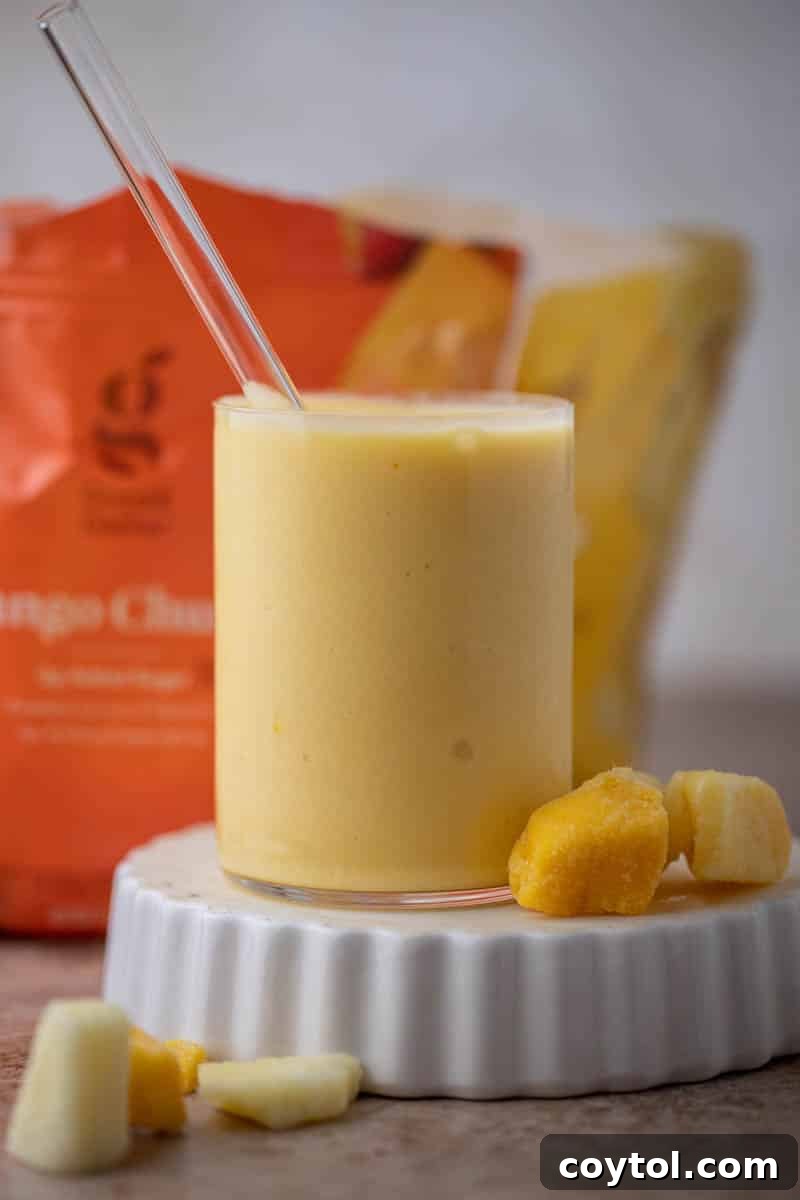 A finished McDonald's mango pineapple smoothie served in a tall glass with a straw.