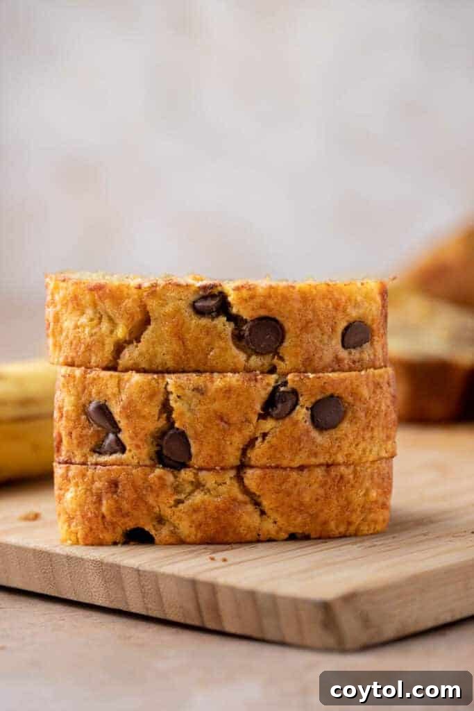 Three golden brown loaves of cake mix banana bread stacked on a cooling rack.