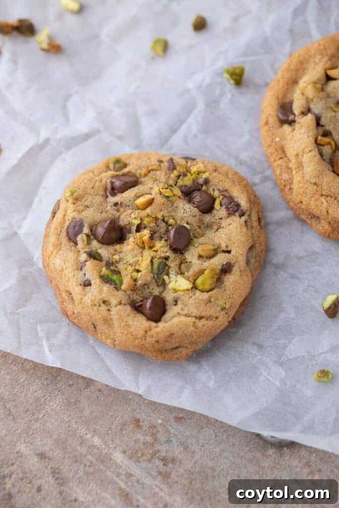 Decadent Brown Butter Pistachio Chocolate Chip Cookies 2 Close-up of a perfectly baked brown butter pistachio chocolate chip cookie, showcasing its crispy edges and soft center with visible chocolate and pistachio pieces.