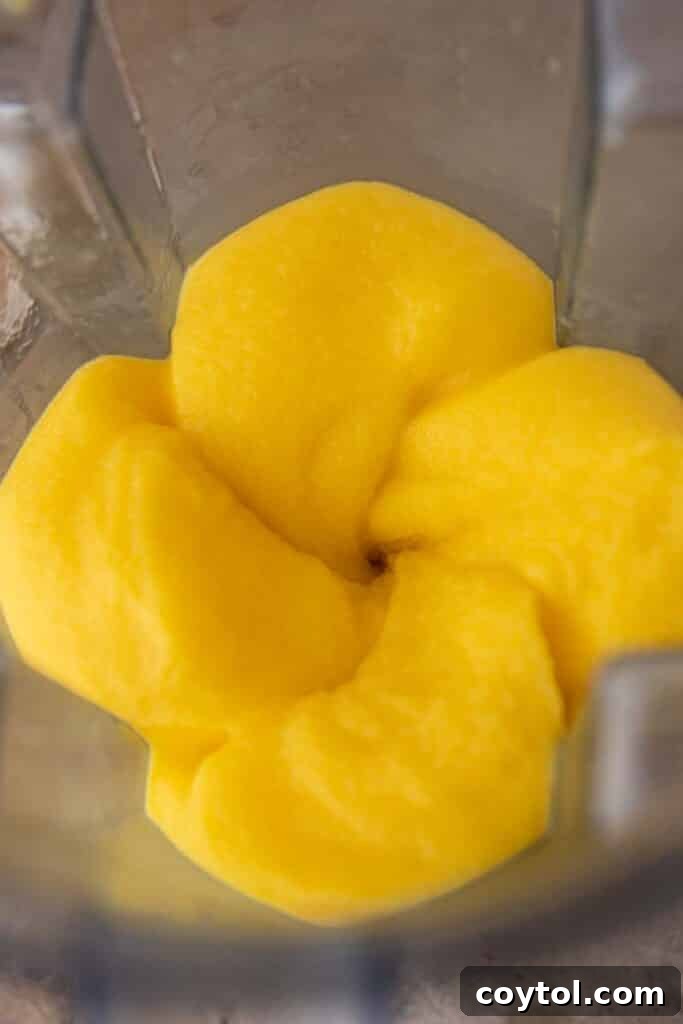 A freshly blended frozen mango margarita in a glass.