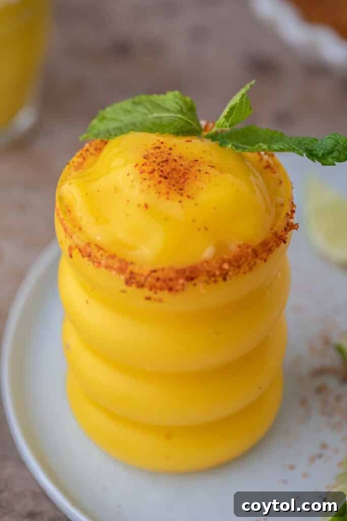 A delicious frozen mango margarita garnished with a lime wedge.