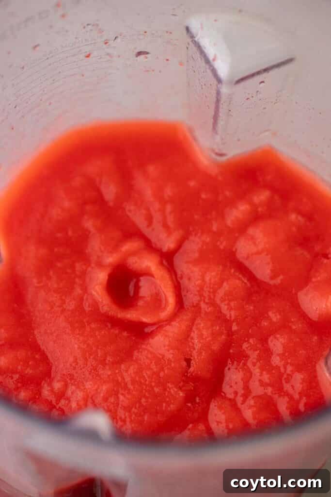 A vibrant, perfectly blended frozen strawberry margarita in a glass.