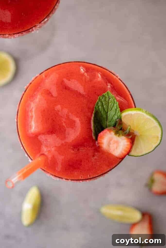Overhead shot of a perfectly blended frozen strawberry margarita in a glass, ready to be enjoyed.