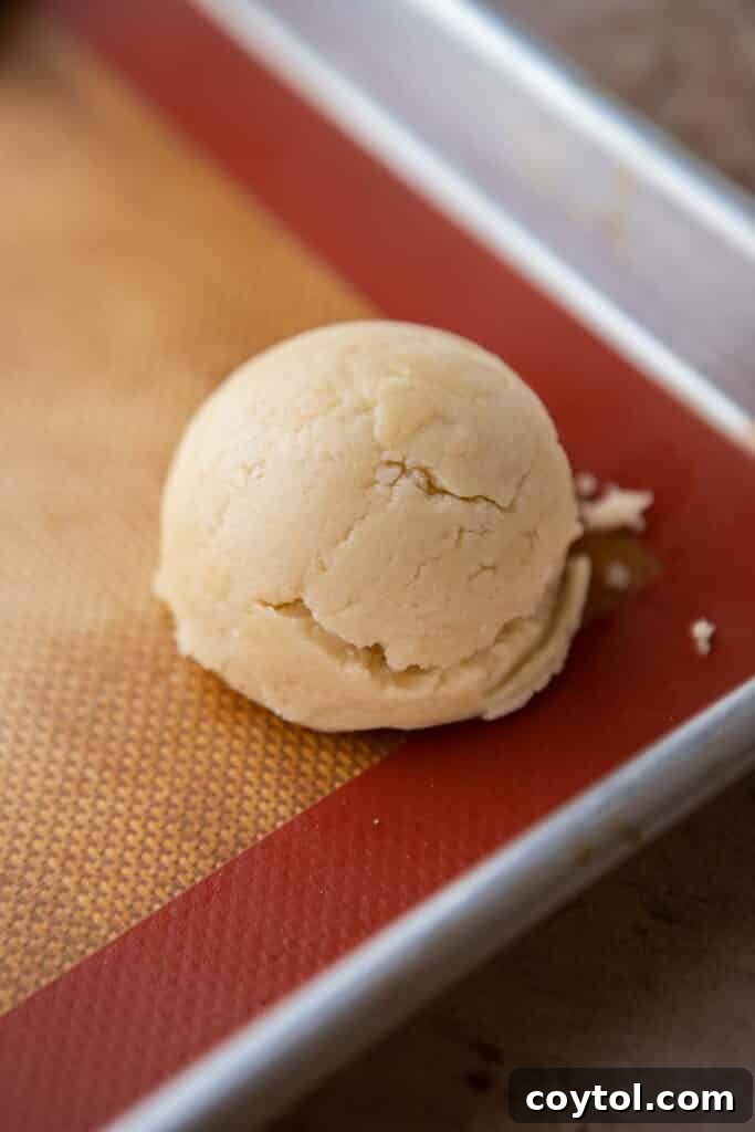 Crumbl All-American Birthday Cake Cookies 8 Scooped cookie dough balls on a parchment-lined baking sheet