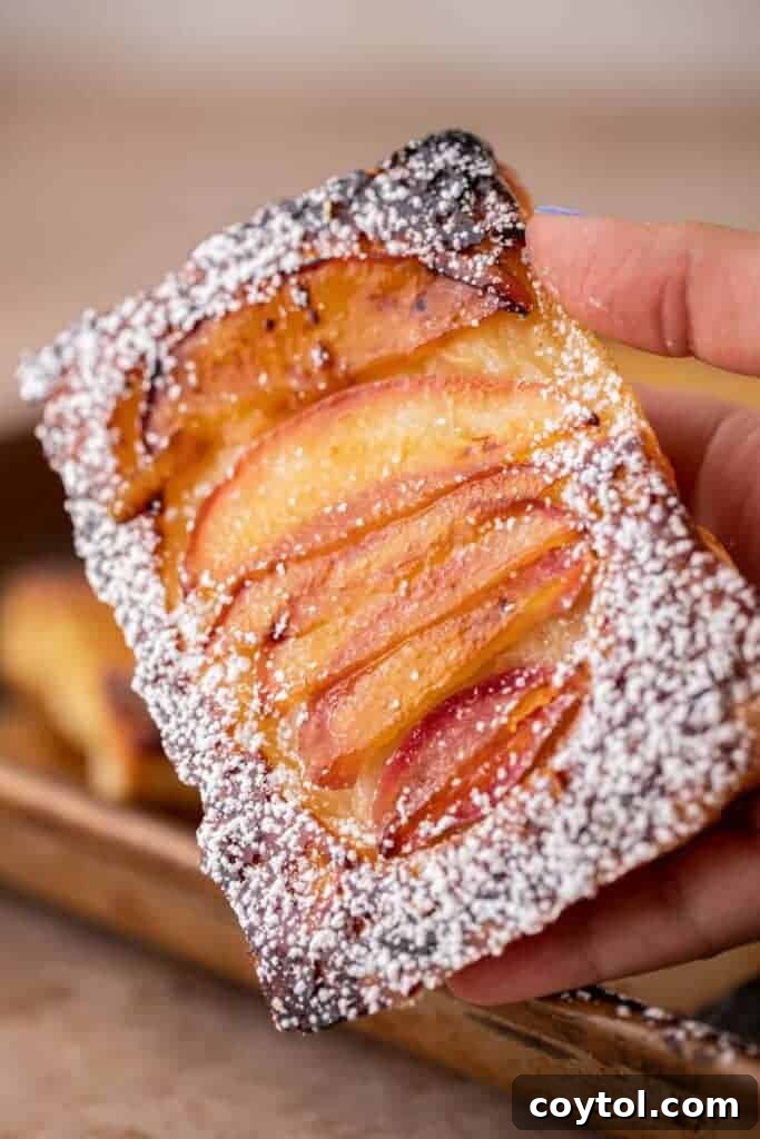 Flip for Flavor: Viral Upside-Down Pastries 2 Hand holding golden-brown viral TikTok upside down pastries with caramelized apples visible.