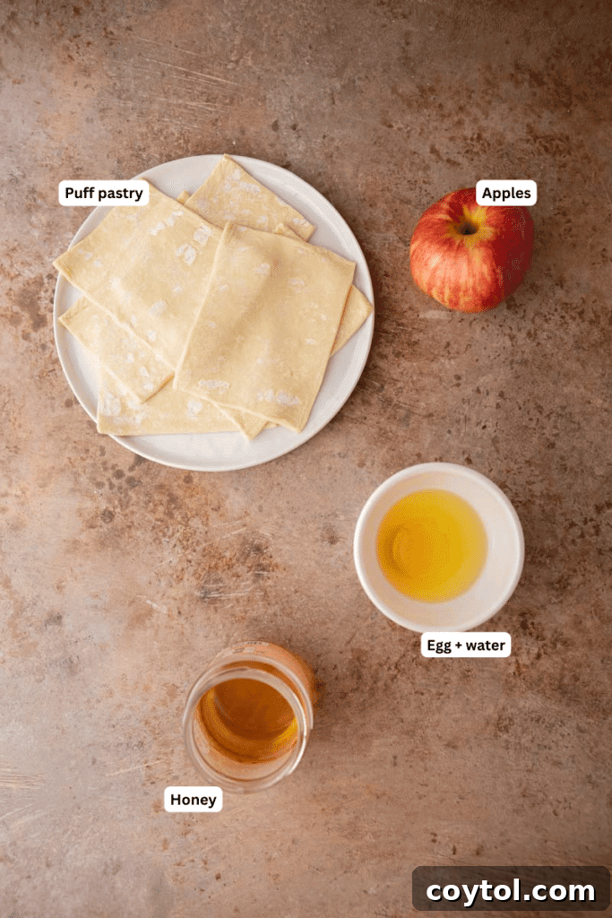 Flip for Flavor: Viral Upside-Down Pastries 3 Fresh ingredients laid out on a kitchen counter for making viral upside down pastries, including apples, puff pastry, honey, and an egg.