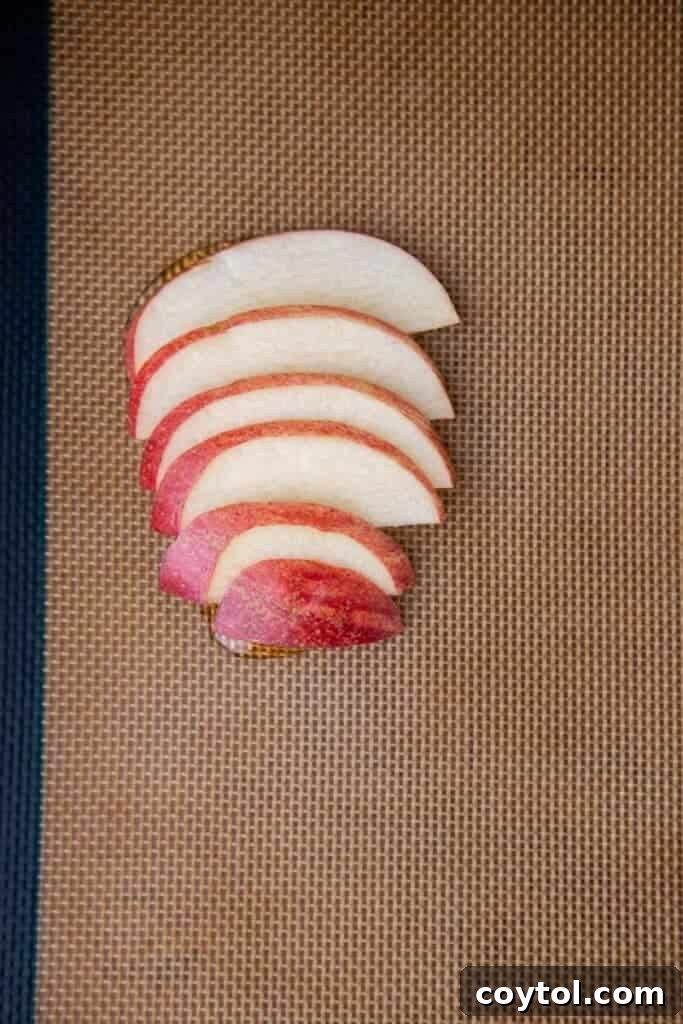 Flip for Flavor: Viral Upside-Down Pastries 5 Thinly sliced apples arranged on a baking sheet, ready for honey.