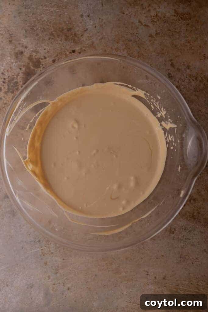 Gently folding the coffee and condensed milk into the whipped cream to create a smooth, airy ice cream base.