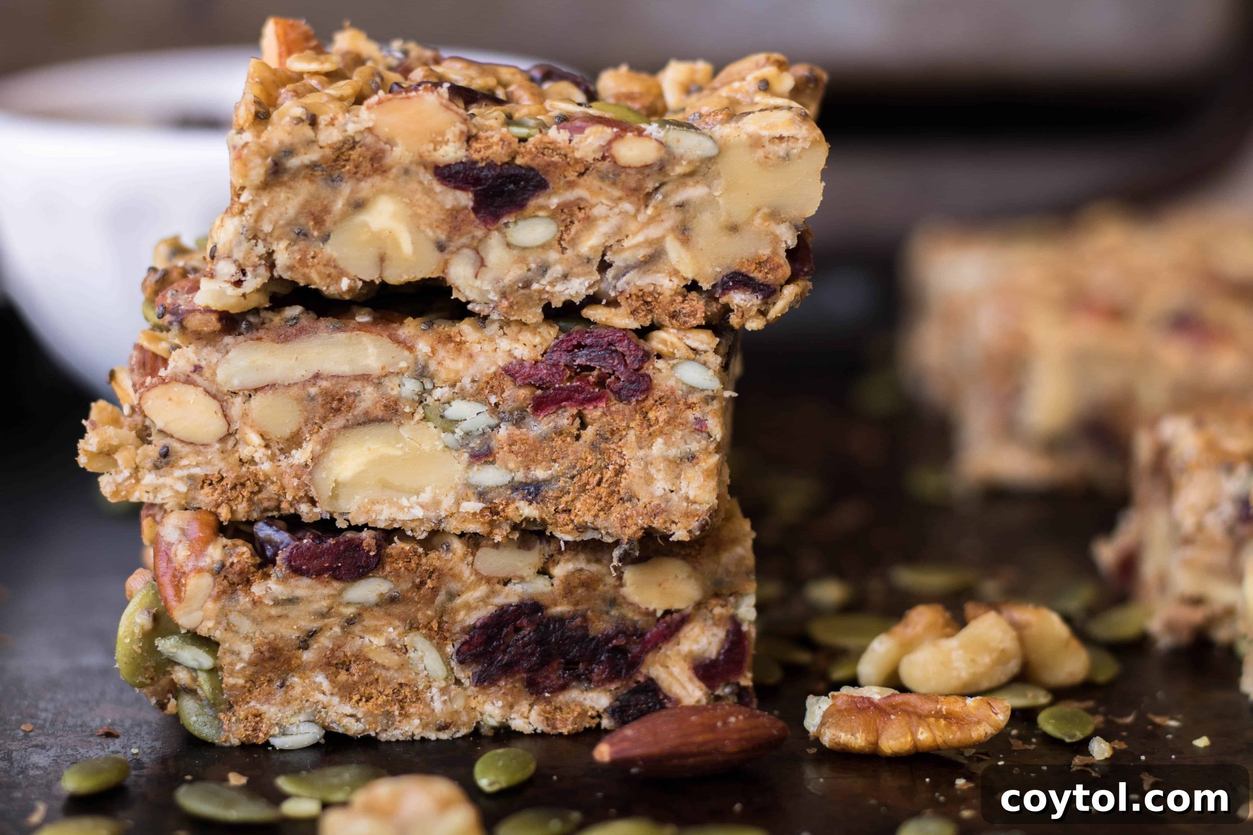 A close-up of a single trail mix energy bar, showing its rich, textured interior.
