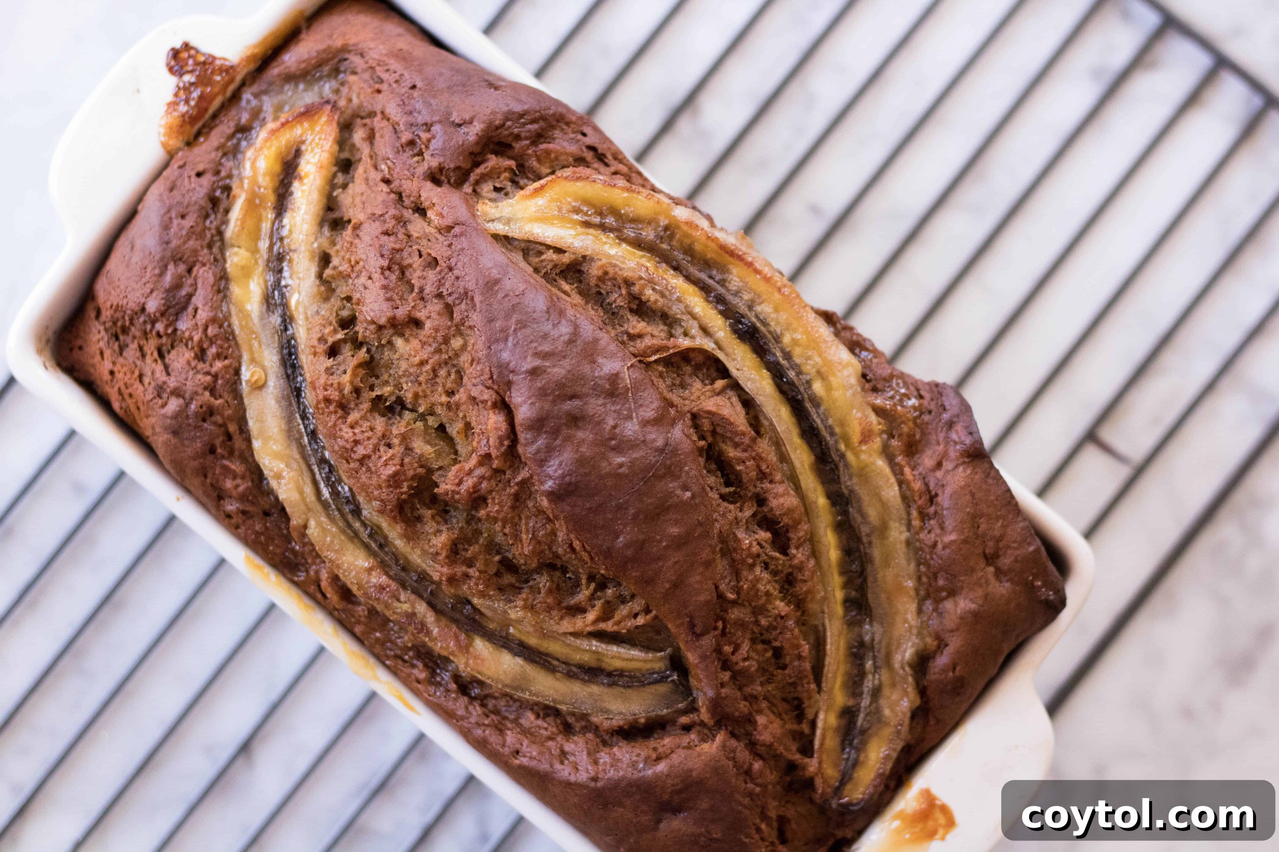Two slices of no sugar added banana bread, one plain and one with nut butter, on a wooden board