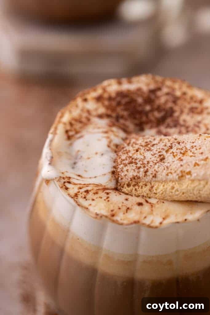 Close up of a homemade tiramisu latte with creamy foam and cocoa dusting.