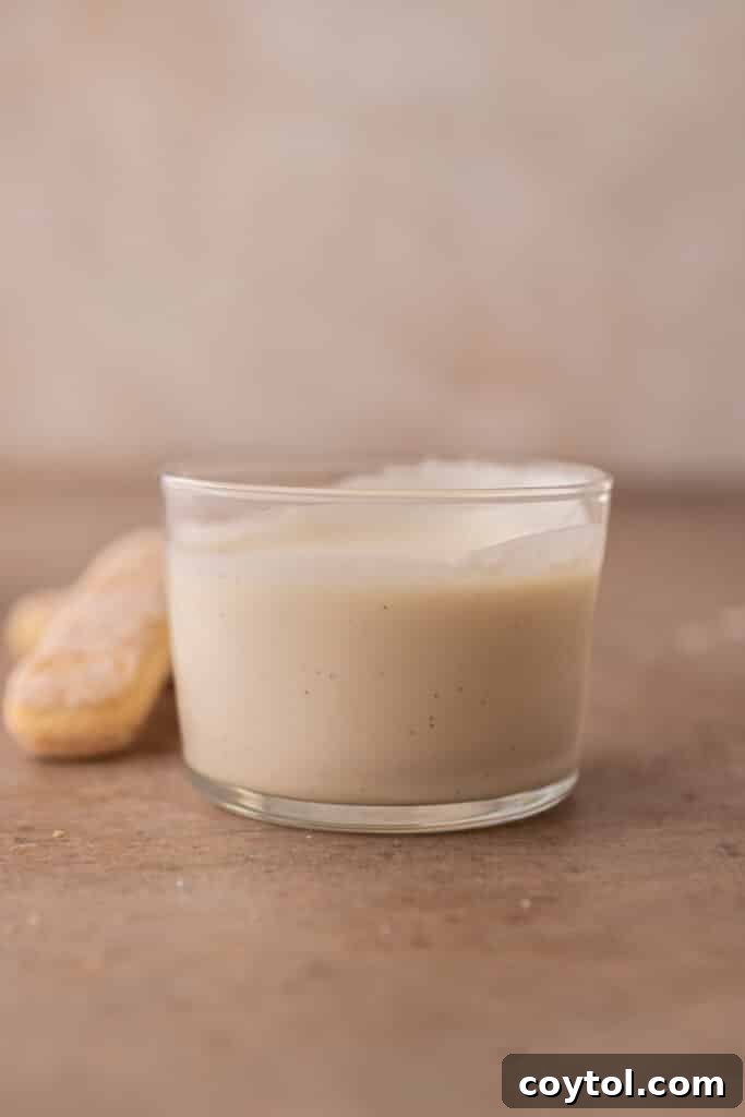 Whipping mascarpone cold foam for tiramisu latte in a measuring cup.