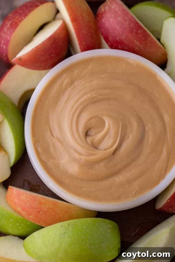 Overhead shot of a bowl of golden homemade caramel dip, surrounded by fresh apple slices, ready for a delicious fall snack.