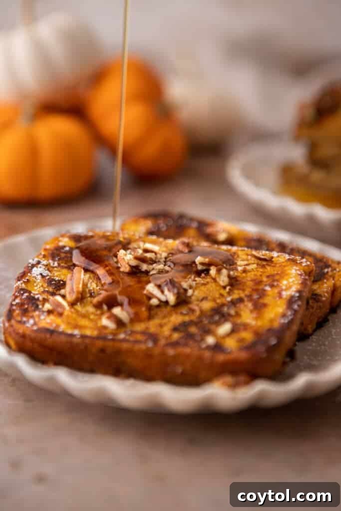 Effortless Pumpkin French Toast Delight 2 Delicious pumpkin french toast with maple drizzle and powdered sugar on top, served on a white plate