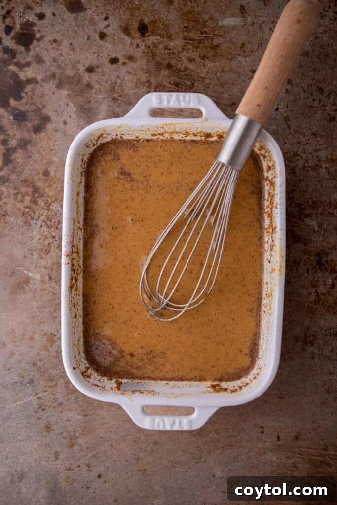 Effortless Pumpkin French Toast Delight 6 Close-up of the perfectly mixed pumpkin custard in a pan, showcasing its smooth texture and rich color.