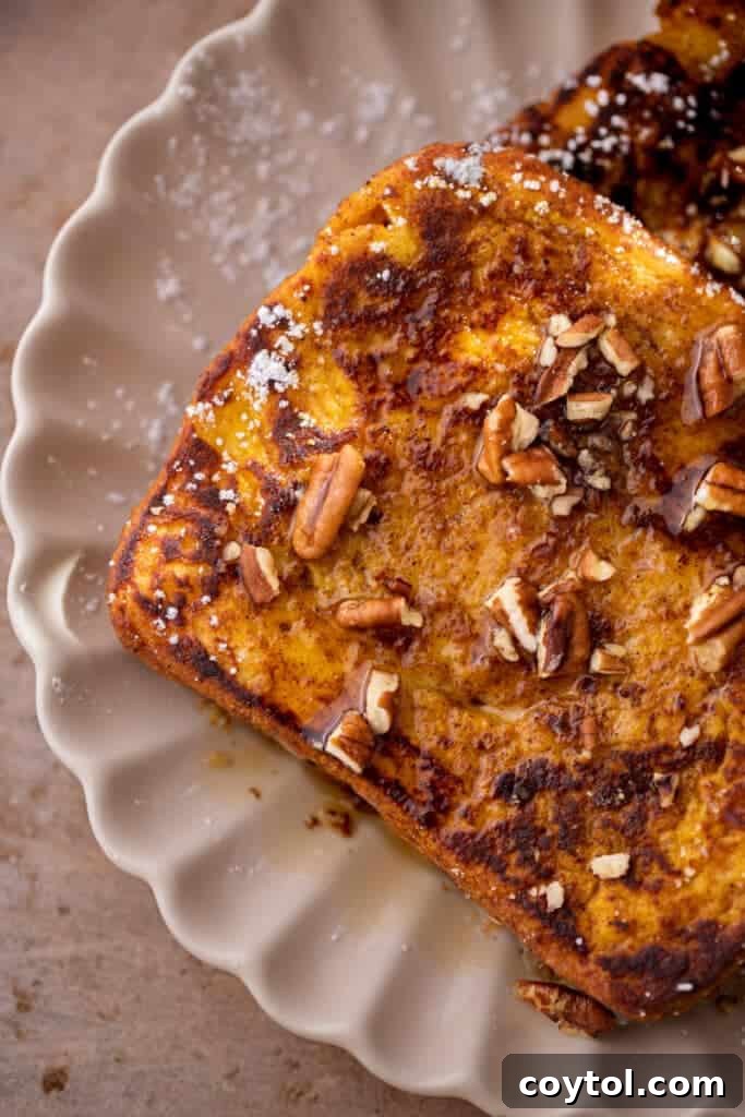 Effortless Pumpkin French Toast Delight 8 An inviting overhead shot of pumpkin French toast, topped with crunchy pecans and a generous drizzle of maple syrup, perfect for a cozy fall breakfast.