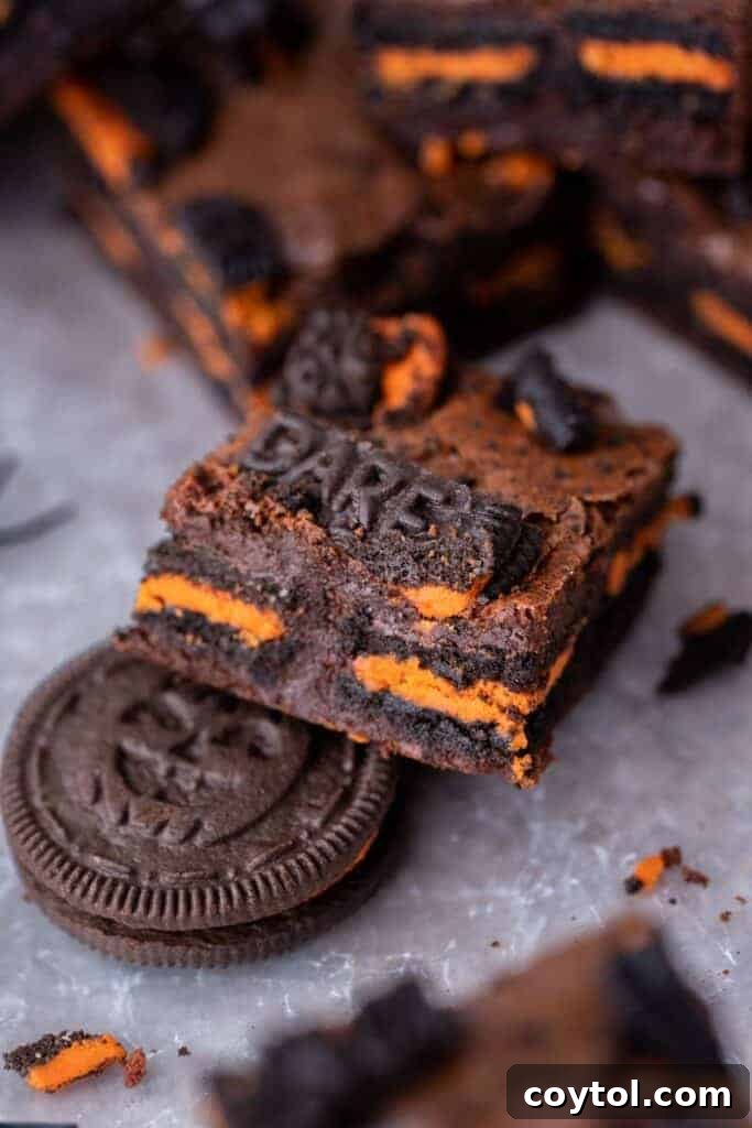 Close-up of a sliced Halloween Oreo brownie showing the fudgy interior and Oreo pieces