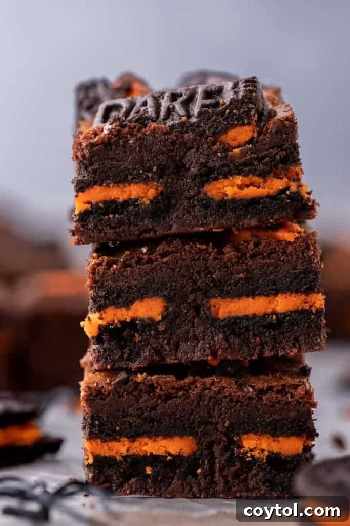 Stack of fudgy Halloween Oreo brownies with visible orange filling