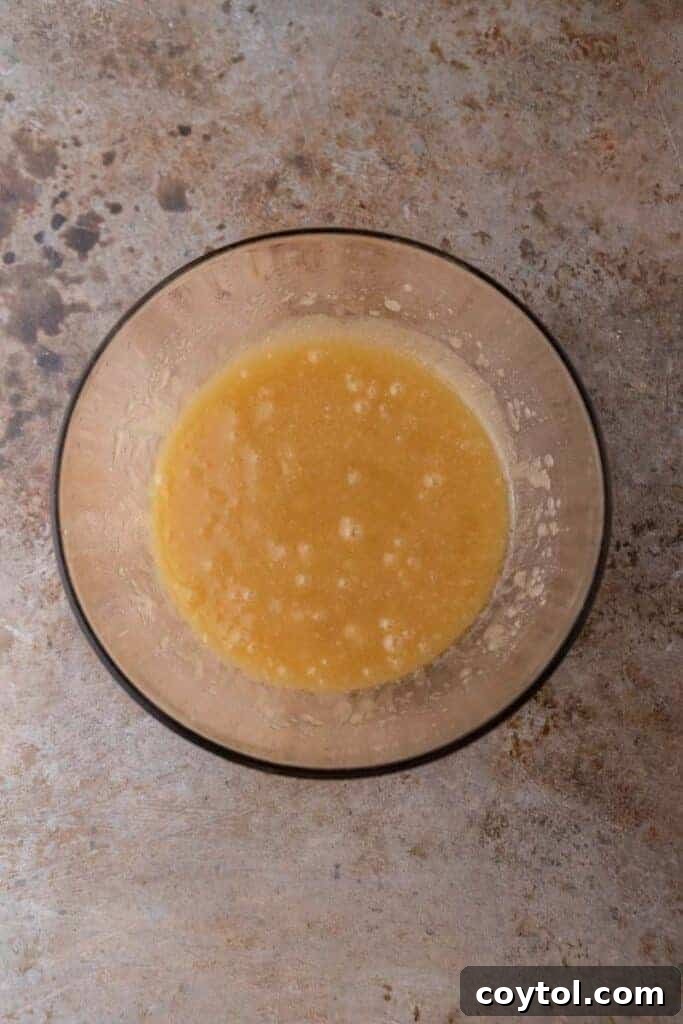 Wet ingredients (melted butter, oil, sugars) in a bowl, ready for mixing