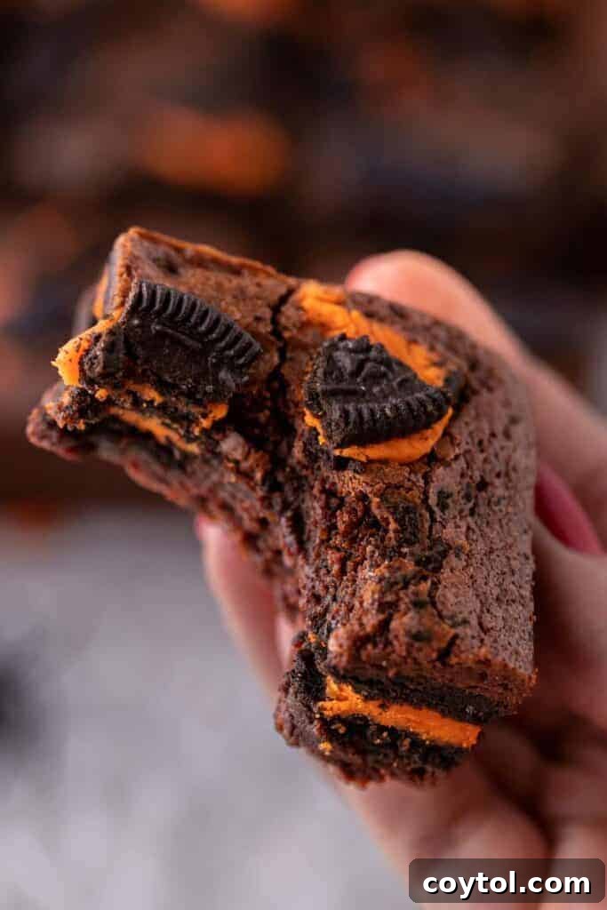 Hand holding a perfectly sliced Halloween Oreo brownie