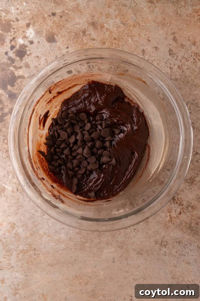 Close-up of brownie cookie batter in a bowl, showcasing its thick, glossy texture and readiness for scooping.
