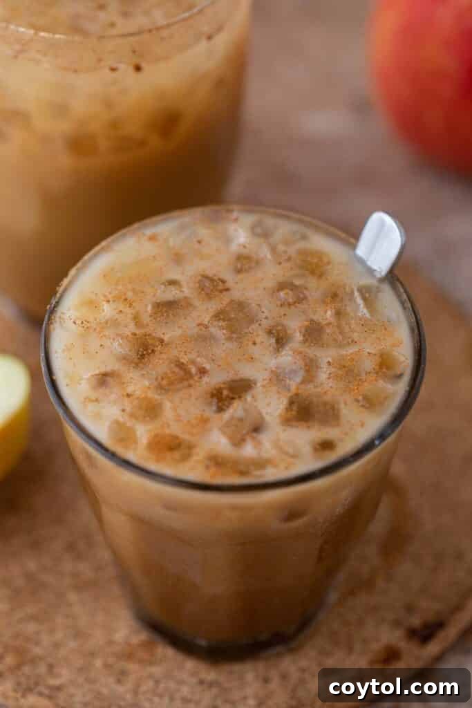 Starbucks Iced Apple Crisp Oatmilk Shaken Espresso 5 A beautifully layered Starbucks iced apple crisp oatmilk shaken espresso, showing the rich brown espresso base, the creamy oat milk, and a delicate sprinkle of cinnamon on top.