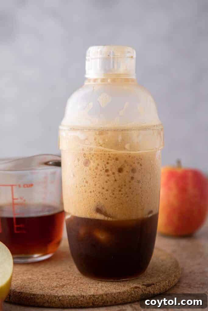 Starbucks Iced Apple Crisp Oatmilk Shaken Espresso 7 Freshly brewed espresso shots being poured into a shaker cup, ready for mixing with the apple crisp syrup and ice.