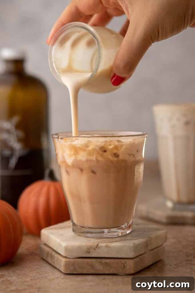 Starbucks' Latest Fall Delight: The Iced Pumpkin Cream Chai Latte 8 Pouring Pumpkin cold foam in a cup