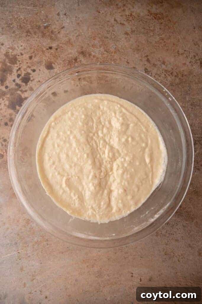 A large glass bowl filled with smooth pancake batter, ready for storage.