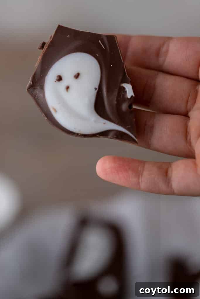 Hauntingly Easy 3-Ingredient Halloween Ghost Bark 4 Hand holding Halloween bark