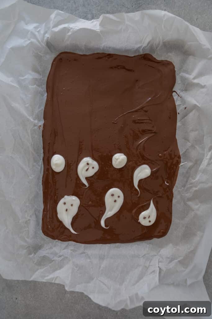Hauntingly Easy 3-Ingredient Halloween Ghost Bark 6 chocolate on the tray with ghosts on half
