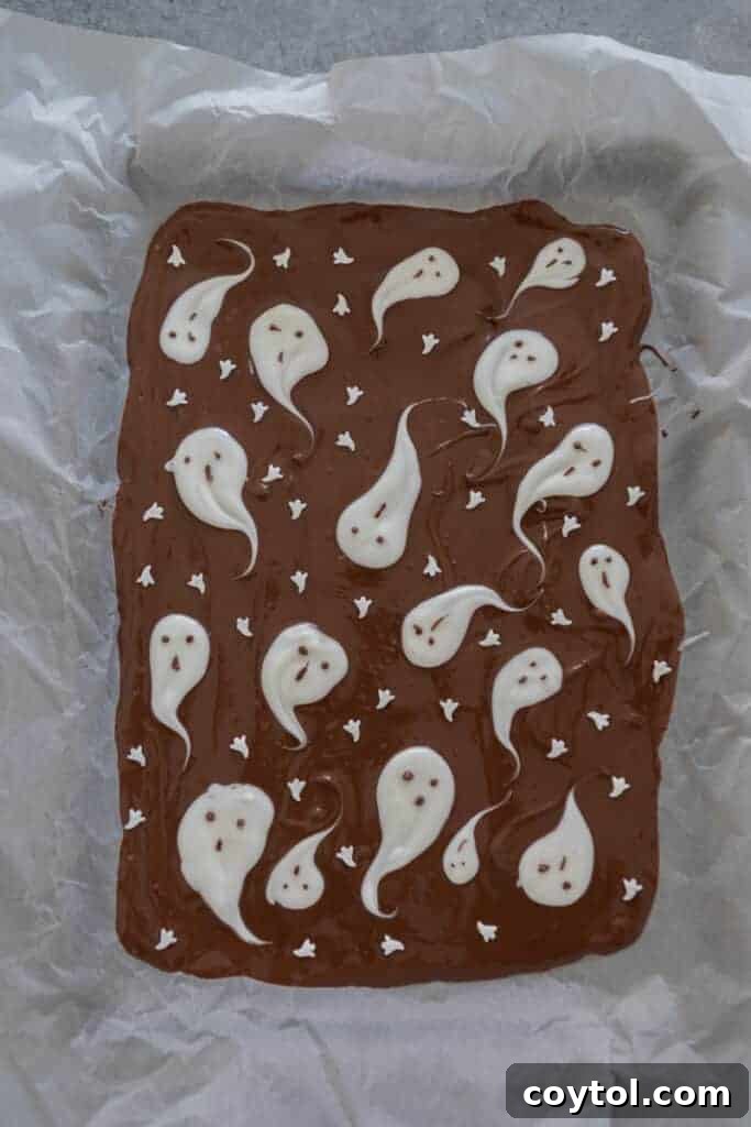 Hauntingly Easy 3-Ingredient Halloween Ghost Bark 7 chocolate on tray with ghosts on it