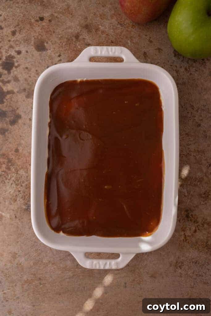Caramel layer being spread over the cheesecake layer for the dip