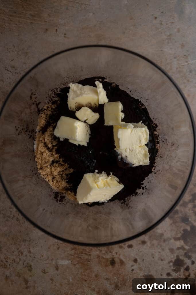 Melted butter, sugars, and black cocoa powder in a mixing bowl.
