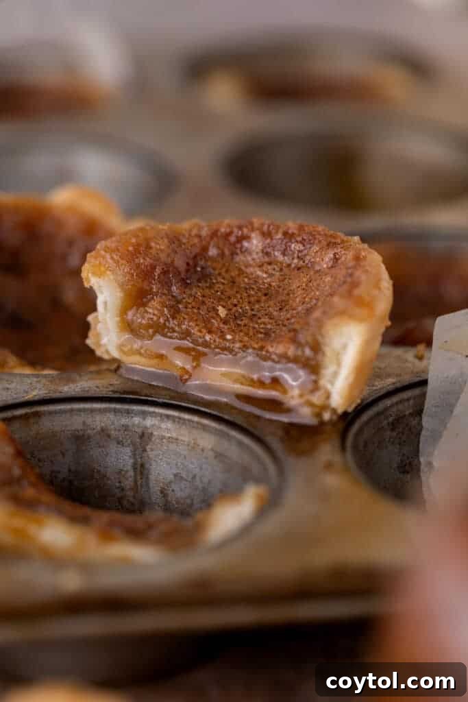 A Canadian butter tart sliced in half, revealing its rich, gooey filling