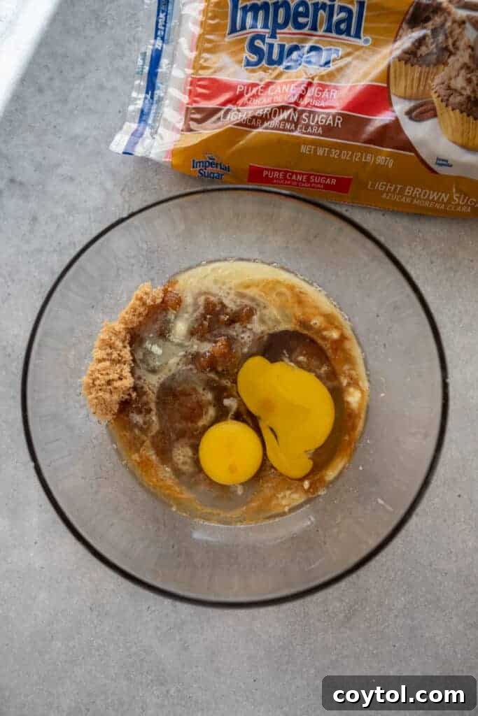 Wet ingredients for butter tart filling, including melted butter and syrup, in a mixing bowl